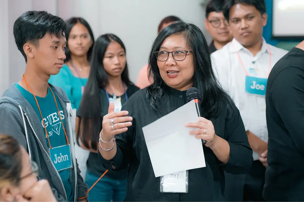 Facilitator Holding Mic And Engaging Youth In Philippines 1